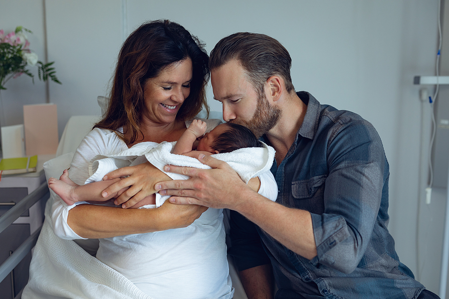 Pärchchen schaut verliebt auf ihr frischgeborenes Baby