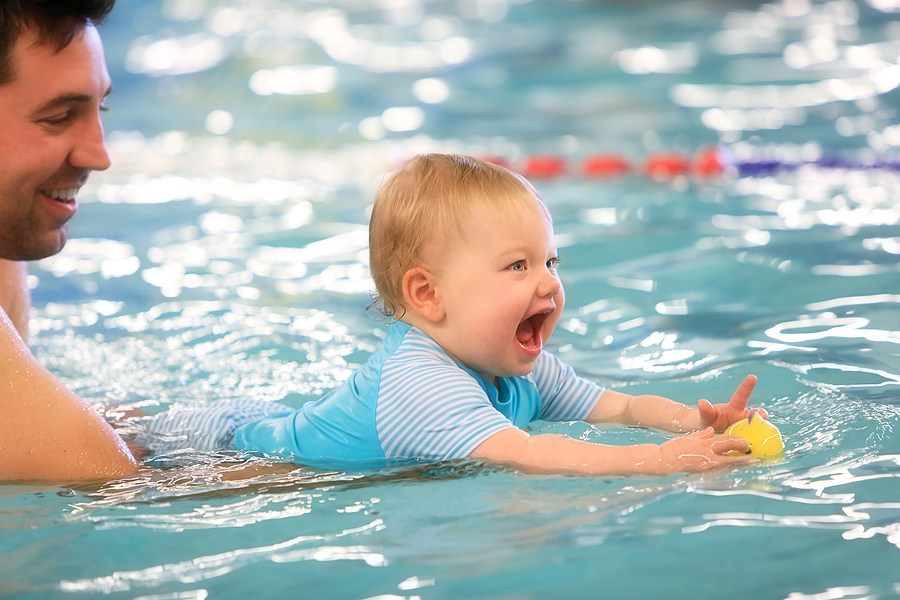 Papa ist mit seinem Baby beim Babyschwimmen.