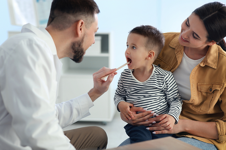 Kinderarzt untersucht Kleinkind während der U7.