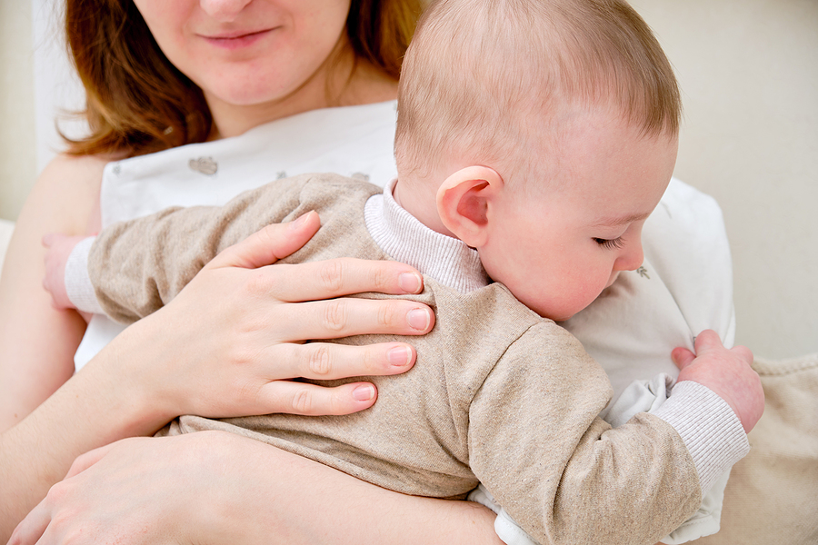 Mama hält ihr Baby mit Gaumenspalte.