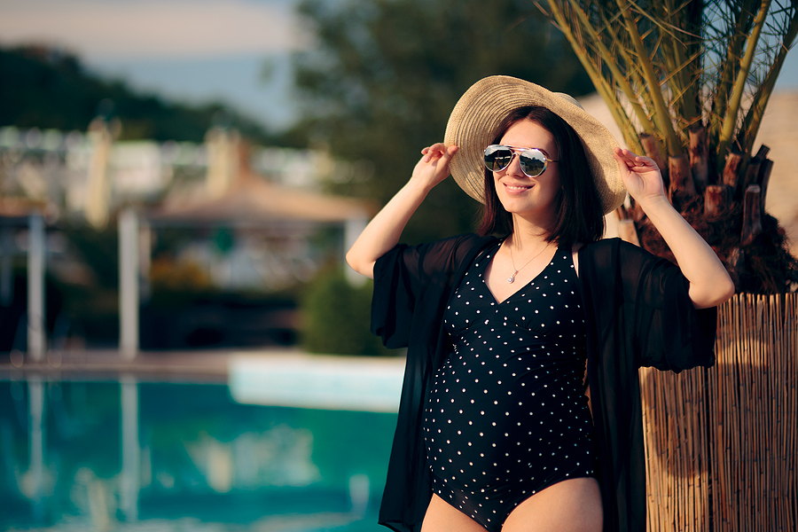 Schwangere genießt ihren Babymoon am Pool.