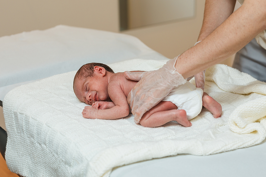 Physiotherapeutin untersucht Baby mit Spina bifida