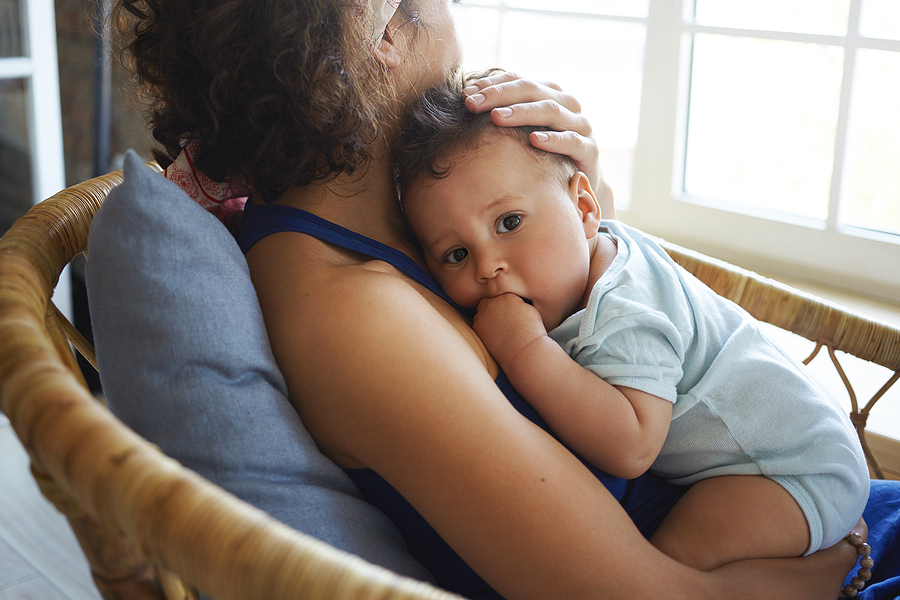 Mumps: Mama kuschelt mit ihrem kranken Baby.