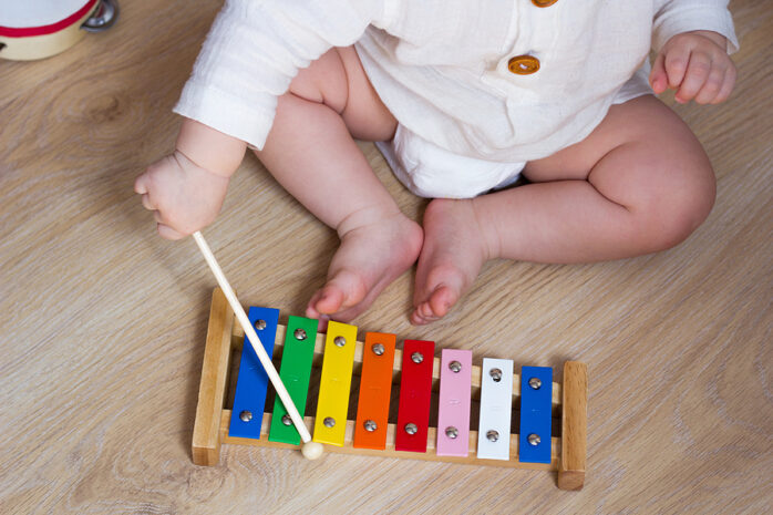 Spielzeug für 1-Jährige: Kleinkind spielt mit Musikpielzeug