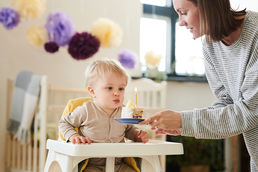 Baby bekommt Geschenke zum 1. Geburtstag und darf die Kerze ausblasen.